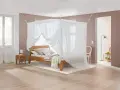 Ein gemütliches Schlafzimmer mit Himmelbett und Moskitonetz, das vor Elektrosmog schützt.