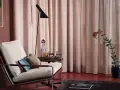 Gemütliche Ecke mit Sessel, Kunstwerk und einem Vorhang nur auf einer Fensterseite.