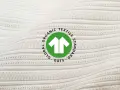 Das GOTS-Zertifikat auf weißem, geripptem Stoff. Es steht für Global Organic Textile Standard und garantiert nachhaltige Textilien.