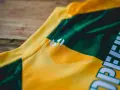 Nahaufnahme eines gelb-grünen **jersey polyester** mit einem weißen Logo.