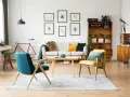 Wohnzimmer im 60er Jahre Style mit Retro-Möbeln, einem Fahrrad und Insektenbildern an der Wand.