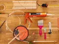 Werkzeuge für Malerarbeiten: Acryl, Stoff, Klebeband und Farbe, die zu schwitzen scheint.