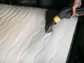 Mit einem Dampfreiniger werden hartnäckige flecken aus matratze entfernen.