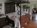 Ein prachtvolles Himmelbett im mittelalterlichen Stil, mit kunstvollen Schnitzereien und einem karierten Bettzeug.