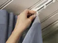 Hand befestigt Gardinenband Haken an der Gardinenschiene. So hängen die Vorhänge perfekt.