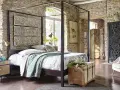 Ein Schlafzimmer mit Steinwänden und einem Himmelbett. Drei Wandpaneele mit orientalischen Mustern hängen über dem Bett. Ein Holztruhe steht am Fußende.