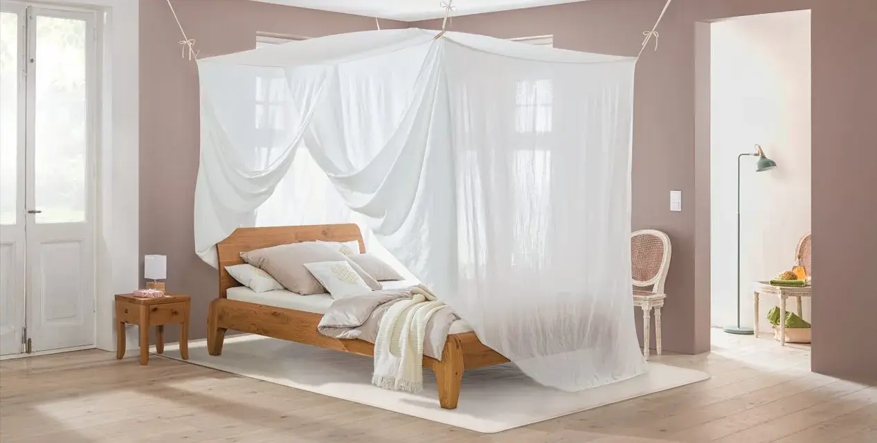 Ein gemütliches Schlafzimmer mit Himmelbett und Moskitonetz, das vor Elektrosmog schützt.