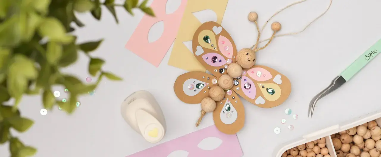 Bastel-Schmetterling mit Holzperlen und Glitzer. Tolle kindergeburtstag ideen zum Selbermachen. Werkzeug und Materialien liegen bereit.
