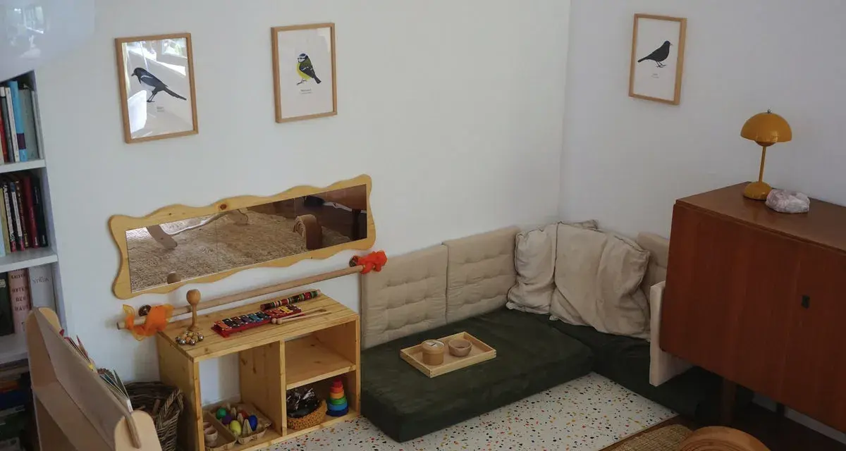 Ein gemütliches Montessori Kinderzimmer mit Spielzeug, Büchern und einer Kuschelecke.