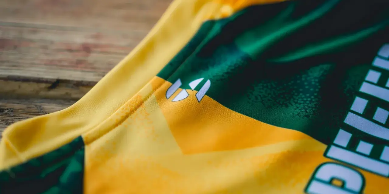 Nahaufnahme eines gelb-grünen **jersey polyester** mit einem weißen Logo.