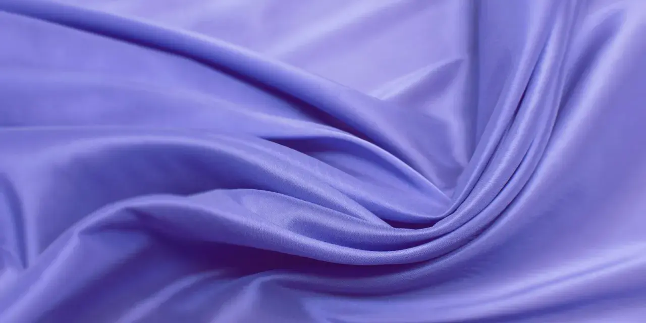 Sanft fließende, lavendelfarbene Viskose. Was ist das? Ein Stoff, der sich wie Seide anfühlt und doch aus Holz gewonnen wird.