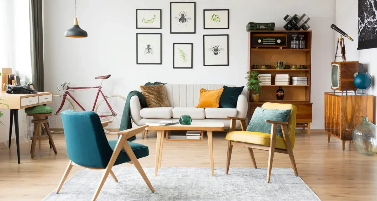 Wohnzimmer im 60er Jahre Style mit Retro-Möbeln, einem Fahrrad und Insektenbildern an der Wand.