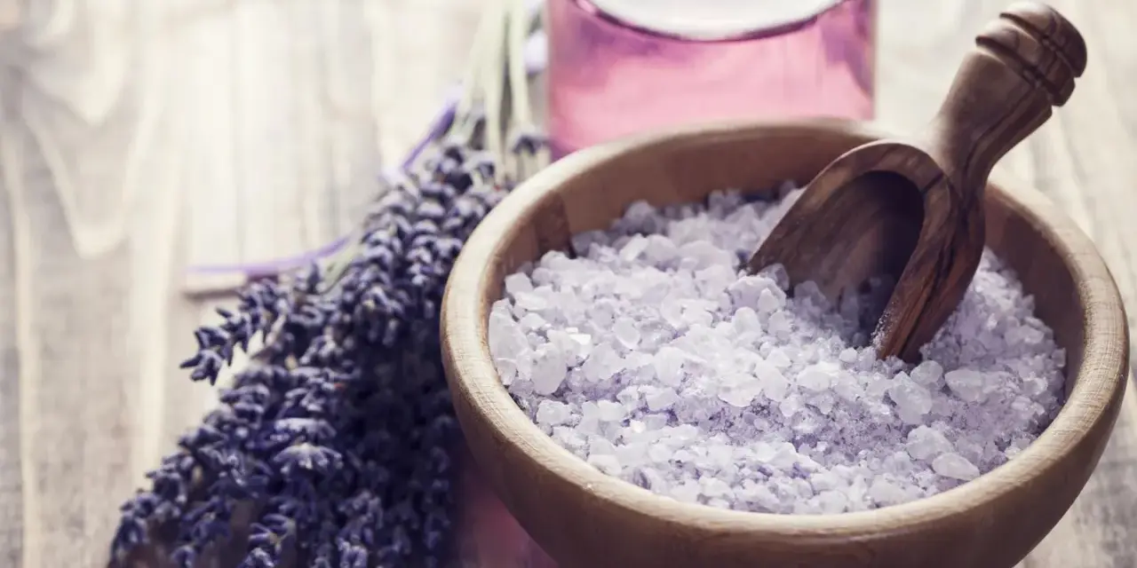 Lavendel und Kristallsalz in einer Holzschale, perfekt zum **Badesalz selber machen** für entspannende Momente.