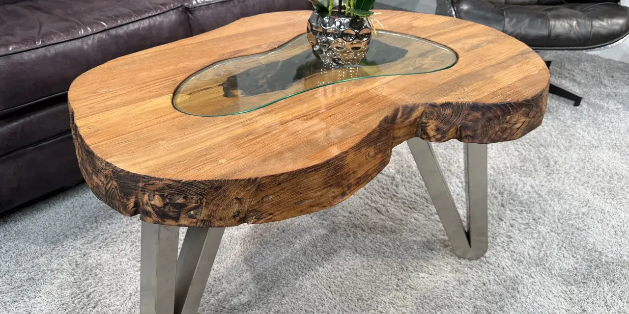 Ein Couchtisch aus massivem Holz mit Glasplatte und Metallbeinen. Die Höhe ist ideal, um Getränke und Snacks bequem zu erreichen.