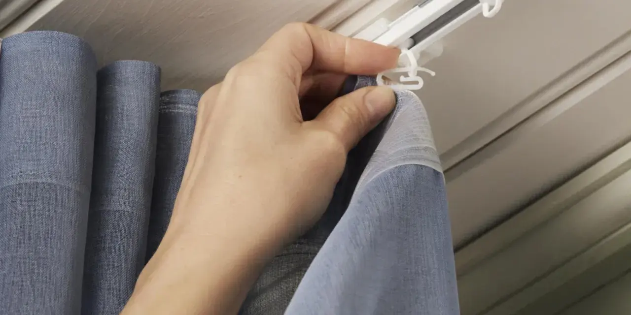 Hand befestigt Gardinenband Haken an der Gardinenschiene. So hängen die Vorhänge perfekt.