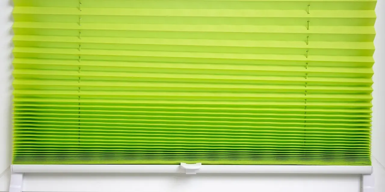Grünes Plissee zu lang, schlimm. Die Falten sind eng und gleichmäßig, die Farbe verläuft von hellgrün zu einem kräftigeren Ton.