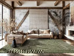 Grüner Teppich mit geometrischem Muster ist dunkler als die helle Couch. Rustikales Wohnzimmer mit Holzbalken und Kamin.