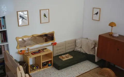 Ein gemütliches Montessori Kinderzimmer mit Spielzeug, Büchern und einer Kuschelecke.