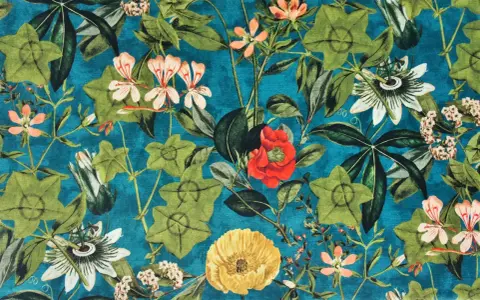 Stoffe mit einem üppigen, vintage Blumenmuster auf petrolblauem Grund. Grüne Blätter und Blüten in Rot, Rosa, Orange und Gelb.