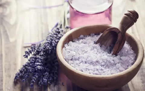 Lavendel und Kristallsalz in einer Holzschale, perfekt zum **Badesalz selber machen** für entspannende Momente.