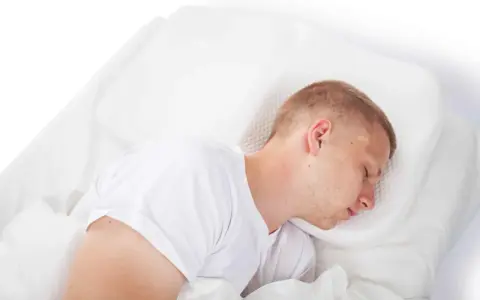 Mann schläft tief und fest, egal ob er flach oder hoch liegt. Sein Schnarchen ist leise.