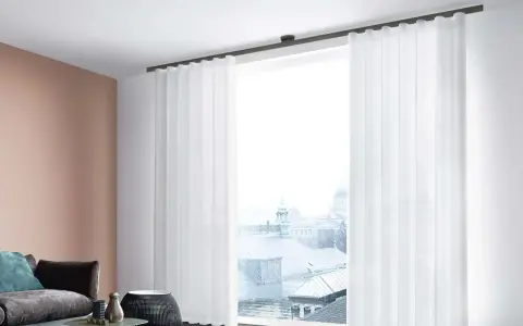 Weiße, transparente Vorhänge mit sanften Wellen und Falten rahmen ein Fenster mit Blick auf eine Stadtkulisse ein.