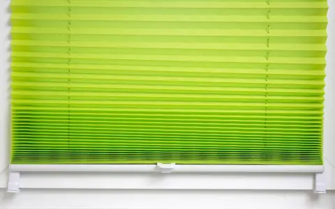 Grünes Plissee zu lang, schlimm. Die Falten sind eng und gleichmäßig, die Farbe verläuft von hellgrün zu einem kräftigeren Ton.