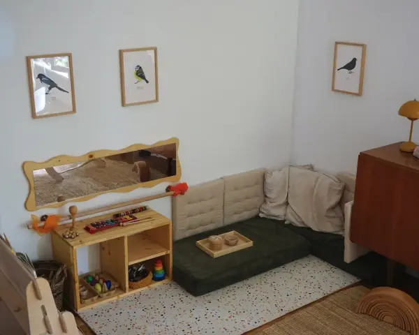 Ein gemütliches Montessori Kinderzimmer mit Spielzeug, Büchern und einer Kuschelecke.