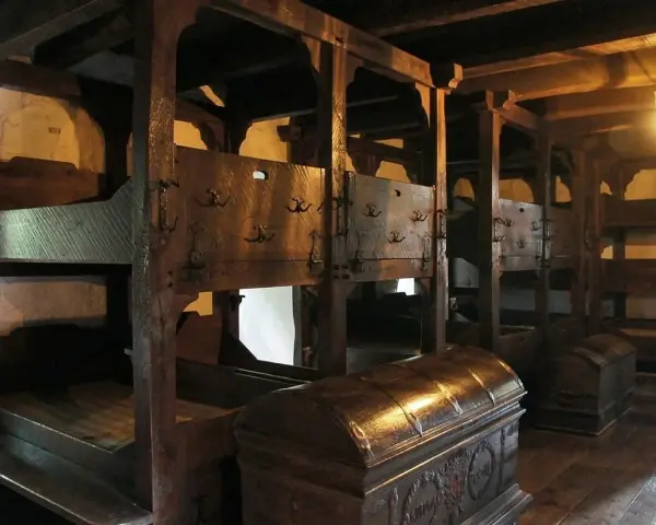 Alte Holzbetten mit Truhen. Wer hat das Bett erfunden? Wahrscheinlich jemand, der es leid war, auf dem Boden zu schlafen.