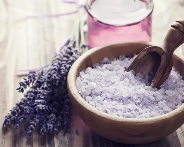Lavendel und Kristallsalz in einer Holzschale, perfekt zum **Badesalz selber machen** für entspannende Momente.