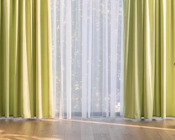 Helle, grüne Gardinen und zarter weiße Stores schmücken das Fenster. Diese Gardinen dekorieren den Raum und lassen viel Licht herein.