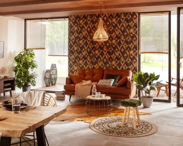 Gemütliches Wohnzimmer mit Ledersofa, Holztisch und afrikanische Muster an der Wand.