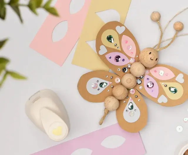 Bastel-Schmetterling mit Holzperlen und Glitzer. Tolle kindergeburtstag ideen zum Selbermachen. Werkzeug und Materialien liegen bereit.