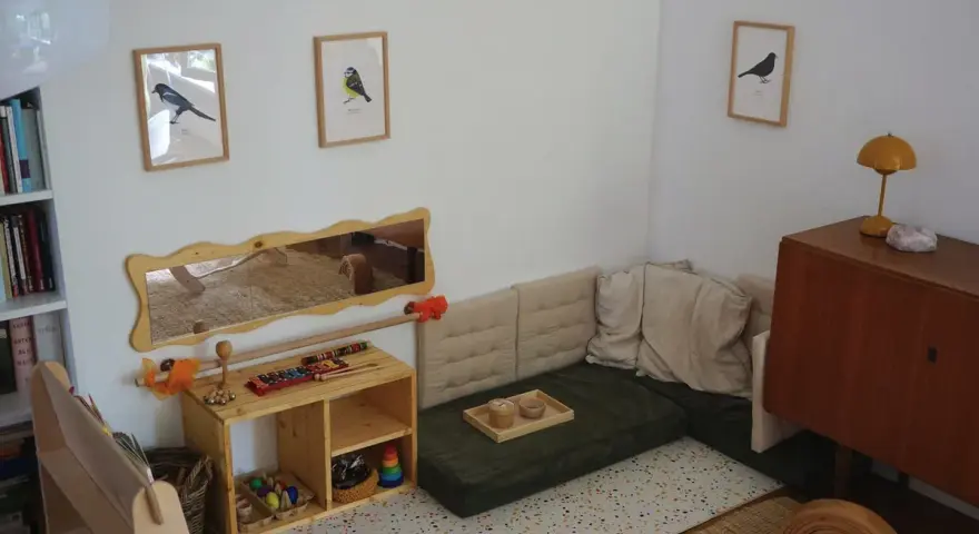 Ein gemütliches Montessori Kinderzimmer mit Spielzeug, Büchern und einer Kuschelecke.