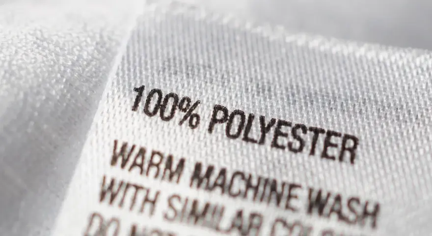 Etikett zeigt "100% POLYESTER". Dieser Stoff ist pflegeleicht und ideal für Kleidung, die oft gewaschen wird.