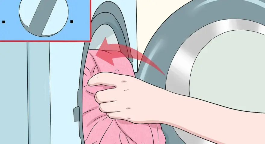 Hand lädt rosa Kleidung in die Waschmaschine. Das Programm "Sanft" ist ausgewählt, damit Viskose richtig gewaschen wird.