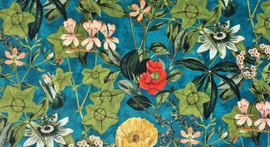 Stoffe mit einem üppigen, vintage Blumenmuster auf petrolblauem Grund. Grüne Blätter und Blüten in Rot, Rosa, Orange und Gelb.