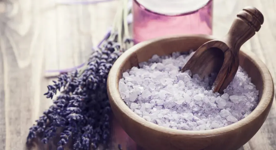 Lavendel und Kristallsalz in einer Holzschale, perfekt zum **Badesalz selber machen** für entspannende Momente.