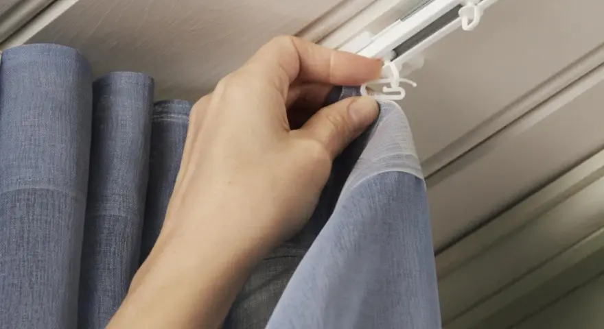 Hand befestigt Gardinenband Haken an der Gardinenschiene. So hängen die Vorhänge perfekt.