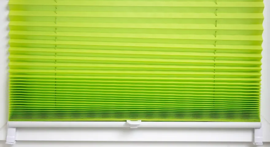 Grünes Plissee zu lang, schlimm. Die Falten sind eng und gleichmäßig, die Farbe verläuft von hellgrün zu einem kräftigeren Ton.