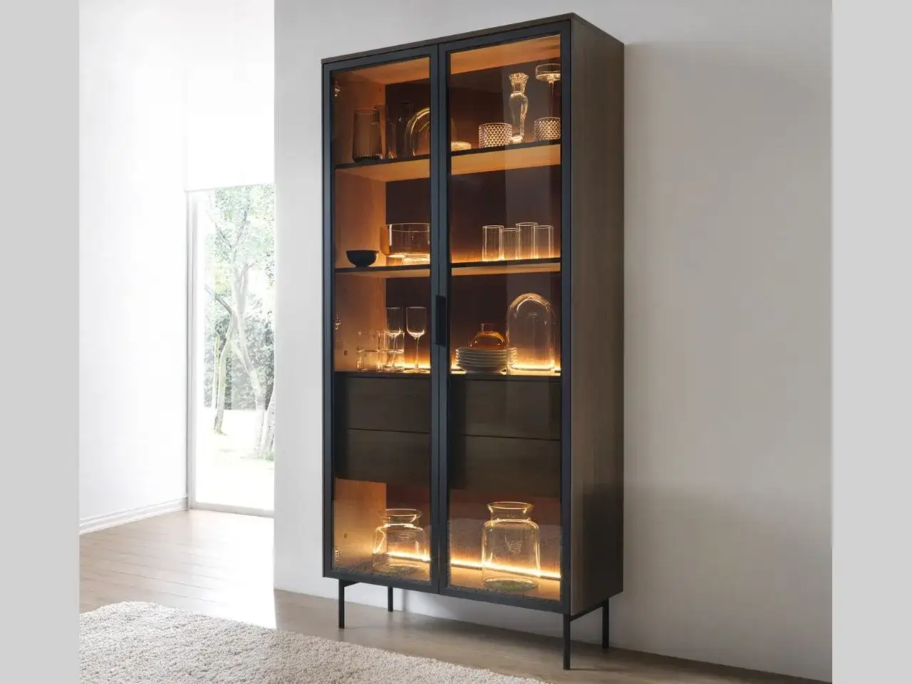 Ein moderner Vitrinenschrank mit Glasfronten, beleuchtet und gefüllt mit Gläsern und Deko-Objekten. Perfekt, um Ihr Zuhause stilvoll zu vitrinenschrank dekorieren.