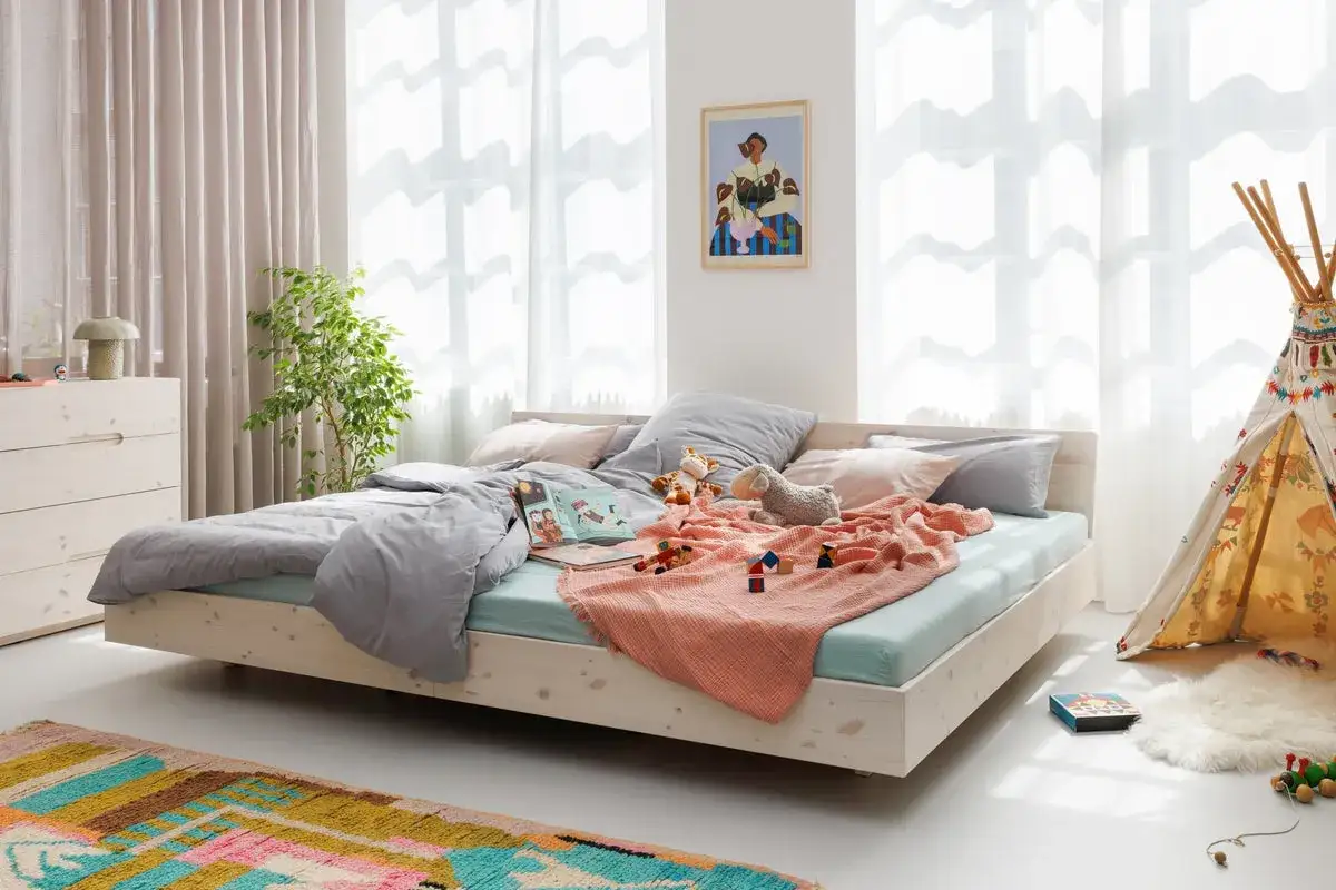 Ein gemütliches Familienbett, bereit für Kuschelstunden und Gute-Nacht-Geschichten. Hier ist Platz für alle!