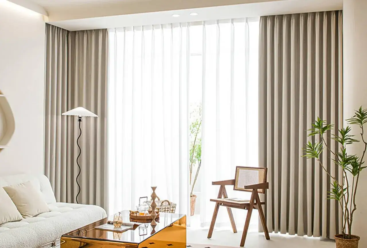 Stilvolle gardinen dekorieren das Wohnzimmer. Helle Stoffe und ein gem&uuml;tliches Sofa schaffen eine einladende Atmosph&auml;re.