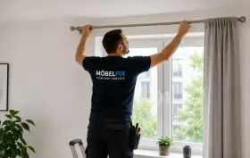 Mann montiert eine Gardinenstange über einem Fenster. Er steht auf einer Leiter und richtet die Stange aus, bevor er sie bohrt.